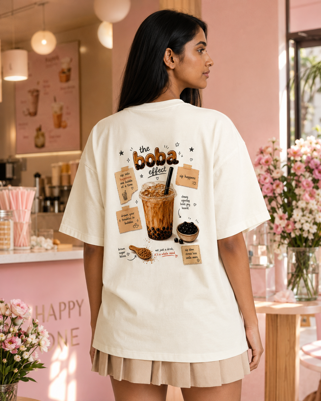 Person wearing a white t-shirt with a graphic design in a cafe setting