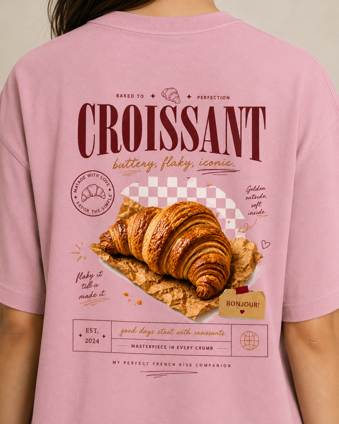 Pink t-shirt with a croissant graphic and text on the back