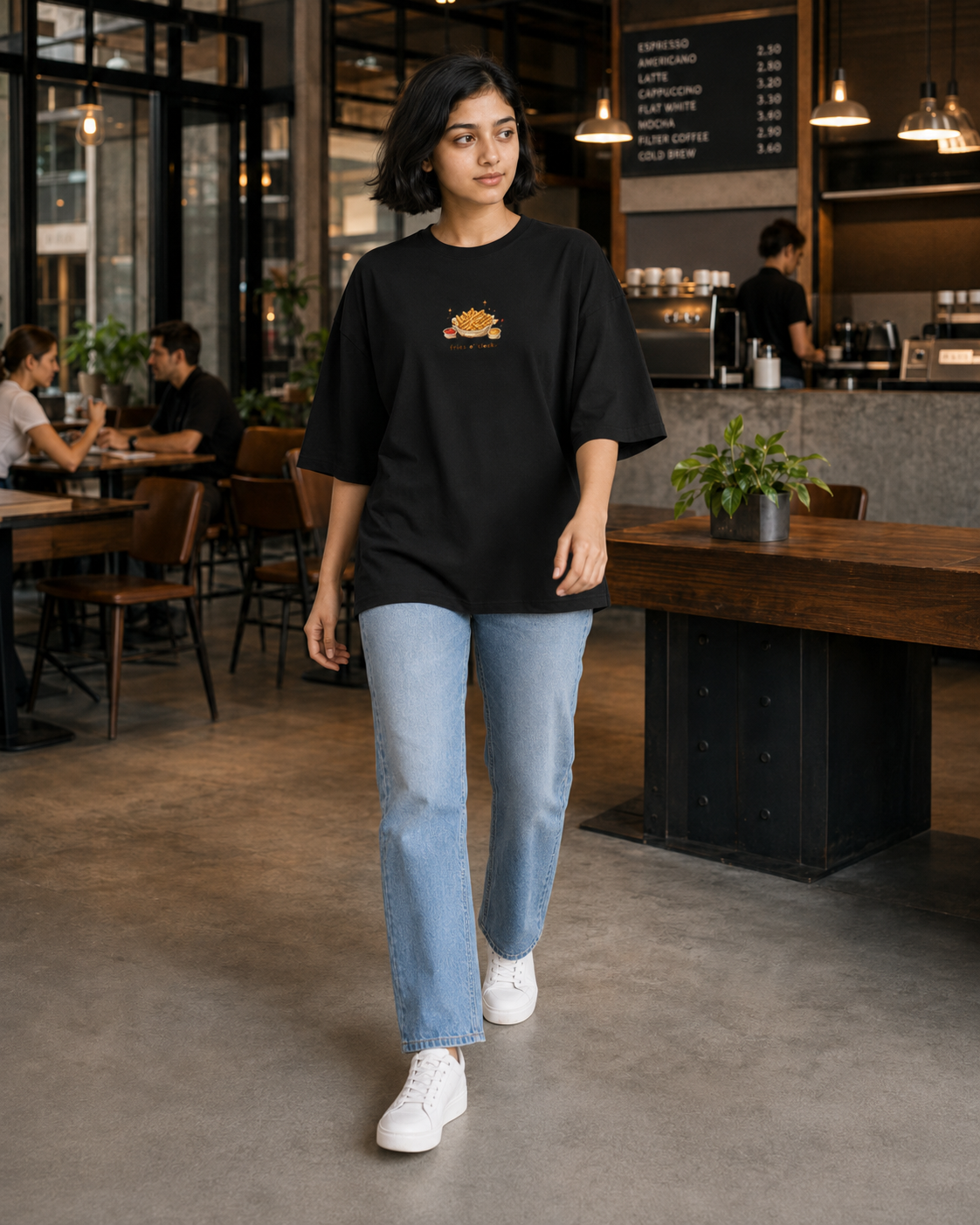Person wearing a black oversized t-shirt with a logo in a casual setting