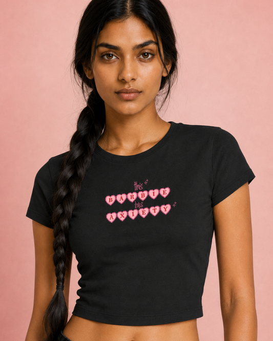 Woman wearing a black t-shirt with pink text on a pink background