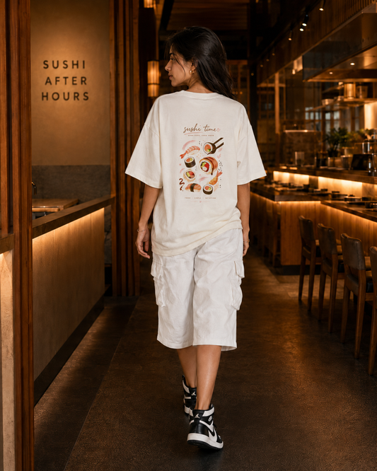 Person wearing a white t-shirt with a sushi design in a restaurant setting